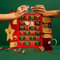 To hænder åbner en nummereret skuffe i Bird & Blends røde adventskalender med te