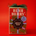 Red Bush Berry box with a green ribbon, a badge reading Advent Teas, and a blue seal that says 24 individual packages of loose-leaf tea.