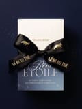 White Le Beau Thé box stacked on a blue Rêve Étoile box labeled 24 thés et infusions, with a black ribbon patterned with gold animals.
