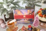 Teabloom Weihnachtsbox mit einer Tasse Tee und Kuchen auf einem verschneiten Tisch