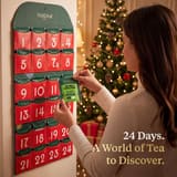 Kvinde, der tager en te fra den hængende sammenfoldelige Vahdam-adventskalender for 2026