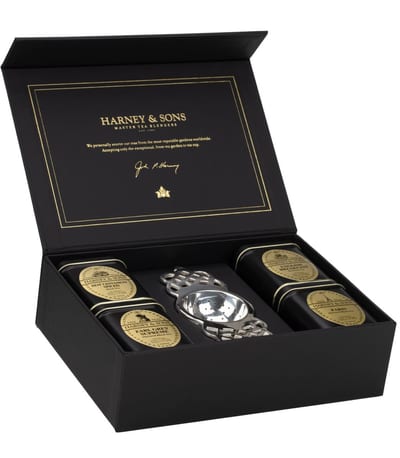 Åben sort Harney & Sons-tekiste med fire dåser løs te