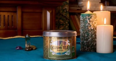 Boîte de thé Kusmi Tsarevna sur une table près de bougies allumées