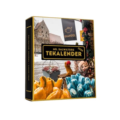 Black and gold box labeled Mr. Salwators Tekalender 2026, with a snowy square on the lid, a spine reading Salwator Handel anno 1984, and peppers and blue-white candy in front.