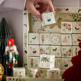 Hand hebt einen nummerierten Würfel aus dem New English Teas Nutcracker Kalender