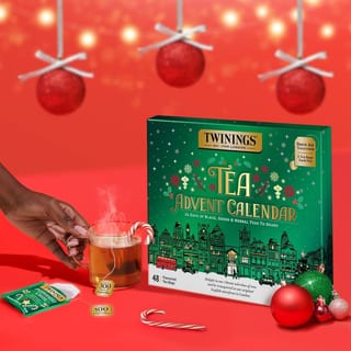 Hand hält eine Tasse Tee neben dem Twinings Brew Joy Together Kalender