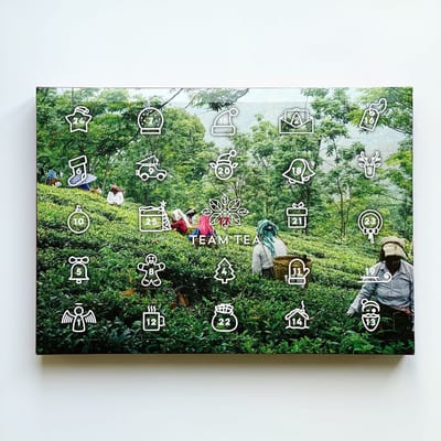 Team Tea box printed with a tea-garden photograph and white outline icons numbered from 1 to 25, including a calendar icon marked 25.