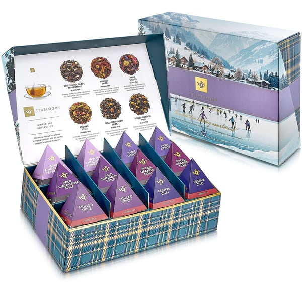 Geöffnete Teabloom Winter Joy Box mit Pyramidenbeuteln neben der Hülle